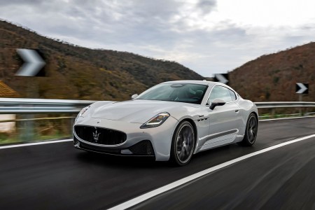 A white 2024 Maserati GranTurismo Modena driving around Italian roads. We tested and reviewed the new grand touring sports car.