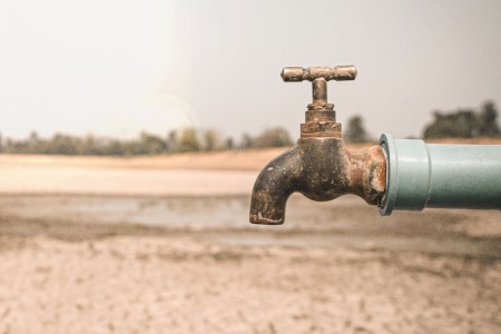 a rusty faucet in front of a desert landscape