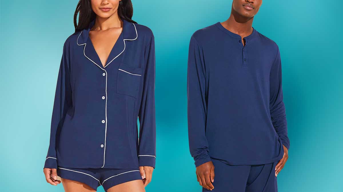 A man and woman model wearing navy Eberjey pajamas