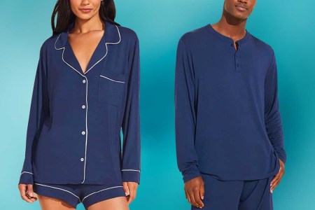 A man and woman model wearing navy Eberjey pajamas