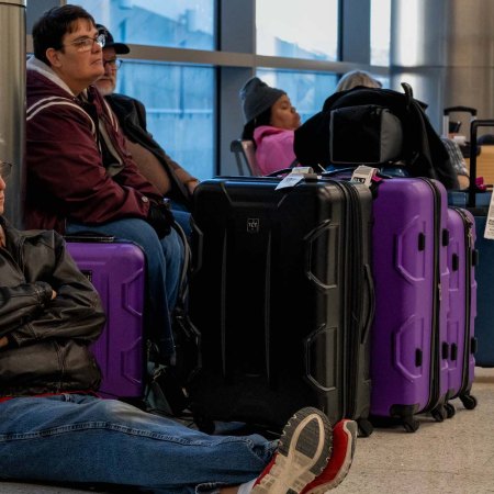 Travelers wait next to their luggage near the Southwest Airlines baggage claim area at the Nashville International Airport