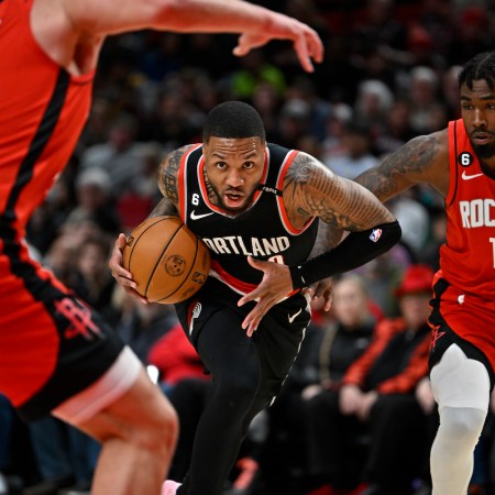 Damian Lillard drives to the hoop between two defenders.