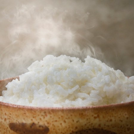 steaming white rice in a brown bowl