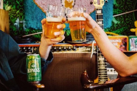 two people cheering pints of hopnosis beer