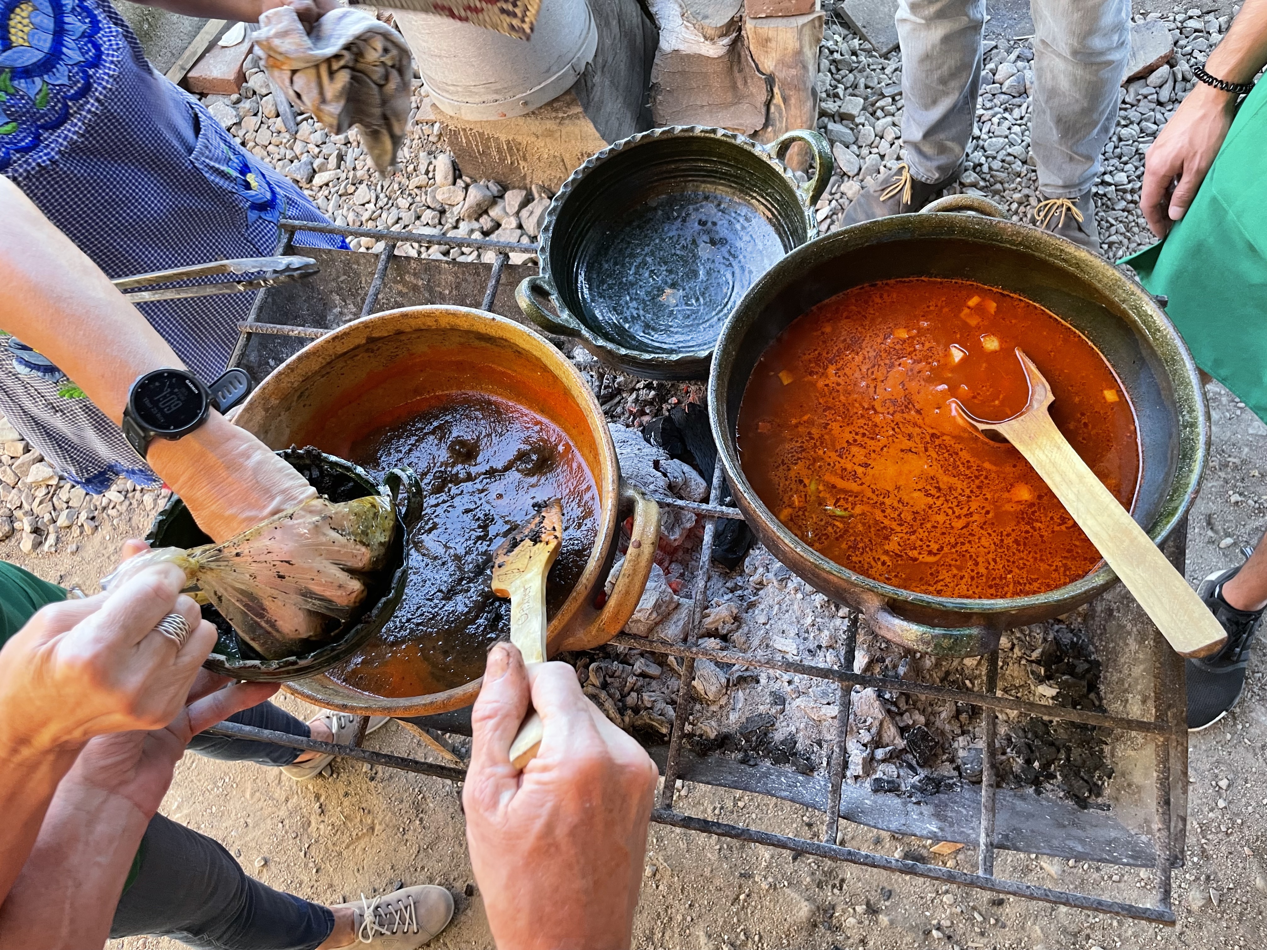 hands cooking traditional oaxacan food over a coal fire