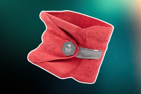 The Trtl Travel neck pillow on a green and red background