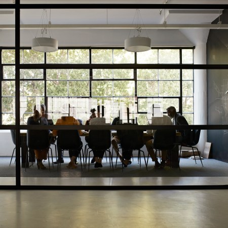 A shot of a board room through a glass window.