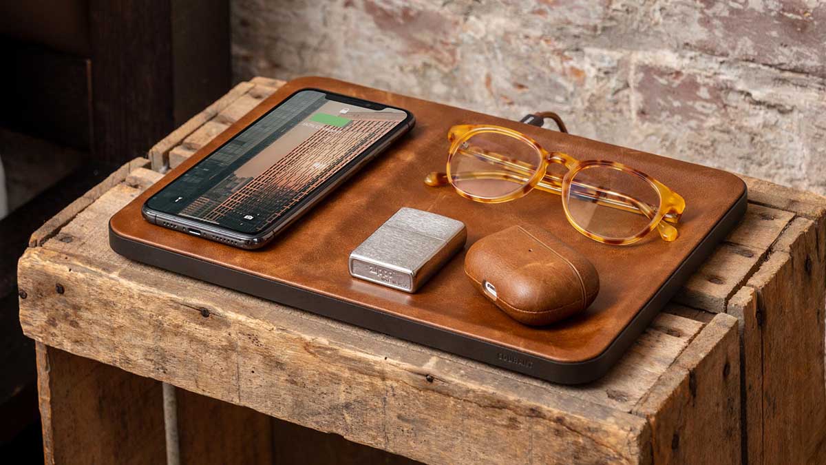 Courant's Catch:3 on a table with glasses and AirPods and a phone. Courant is throwing a sale on tech accessories for Valentine's Day.