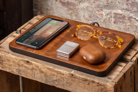 Courant's Catch:3 on a table with glasses and AirPods and a phone. Courant is throwing a sale on tech accessories for Valentine's Day.