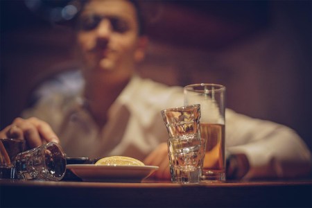 Young drunk man sleeping on bar counter in pub.