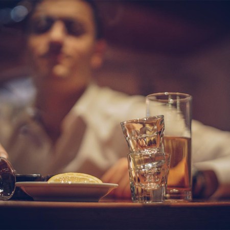 Young drunk man sleeping on bar counter in pub.