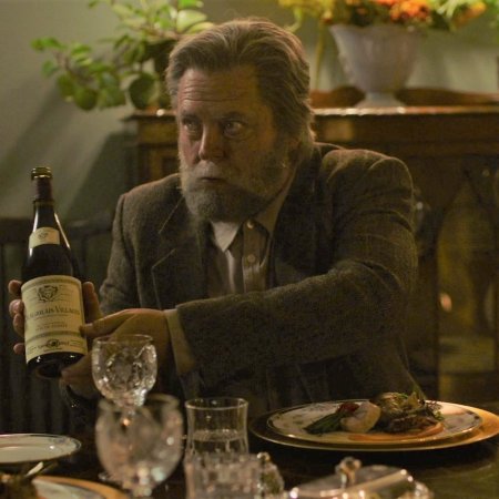 dinner scene from the last of us with nick offerman holding a bottle of wine