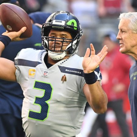 Russell Wilson throws the ball as Pete Carroll looks on in 2022.