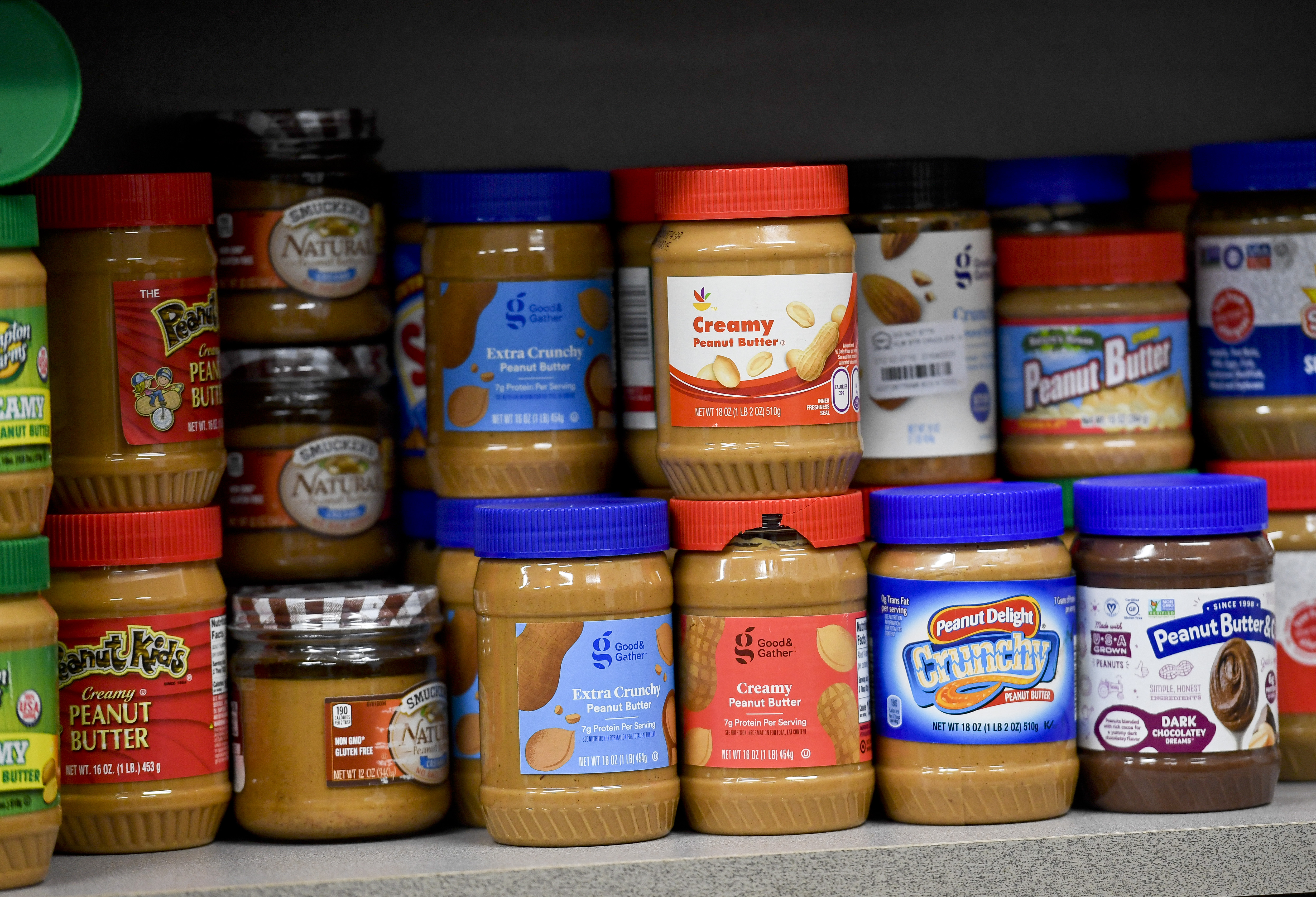 A shelf of peanut butter at the grocery store.