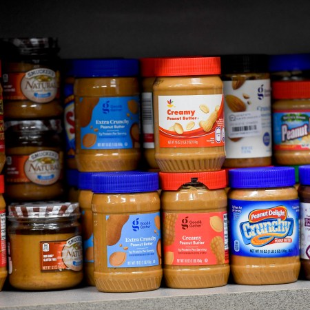 A shelf of peanut butter at the grocery store.