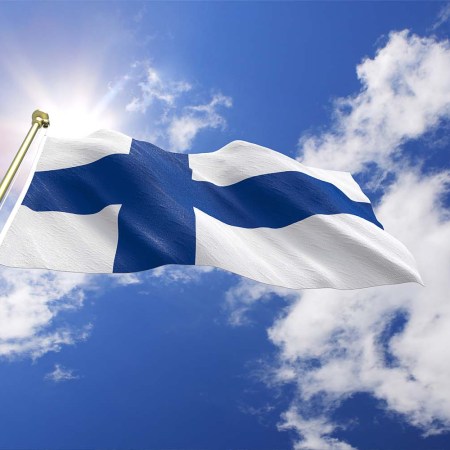 finland flag against a blue sky with white clouds