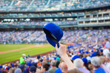 Man holding up baseball cap.