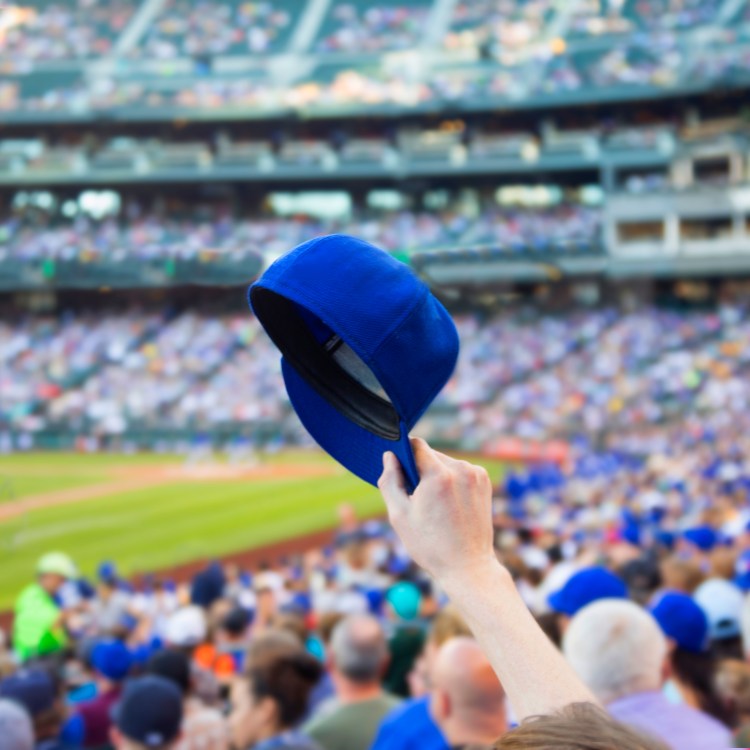 Man holding up baseball cap.