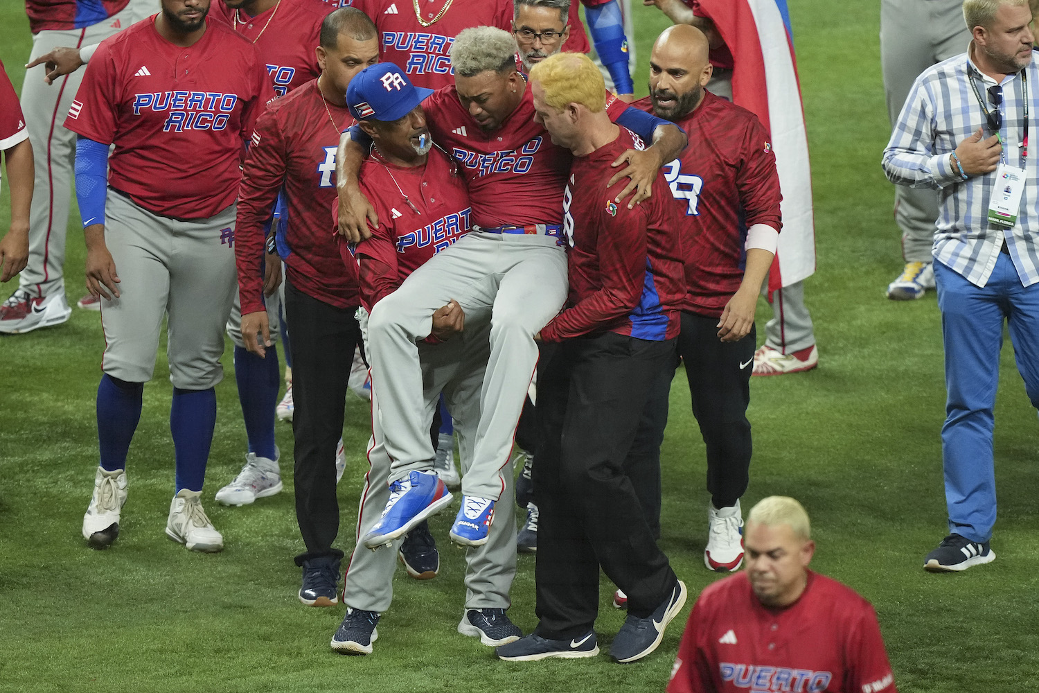 Edwin Diaz #39 of Puerto Rico is helped off the field after being injured during the on-field celebration after defeating the Dominican Republic during the World Baseball Classic Pool D at loanDepot park on March 15, 2023 in Miami, Florida.