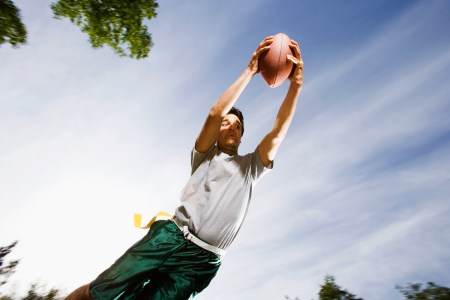 A male flag football player makes a diving catch