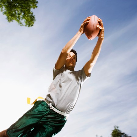 A male flag football player makes a diving catch