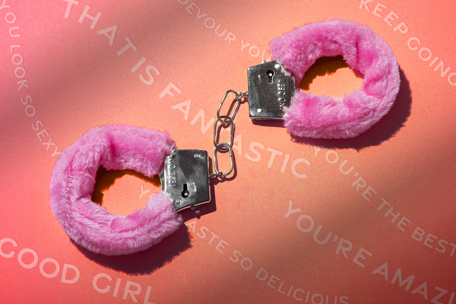 pink fuzzy handcuffs laying on top of positive affirmations