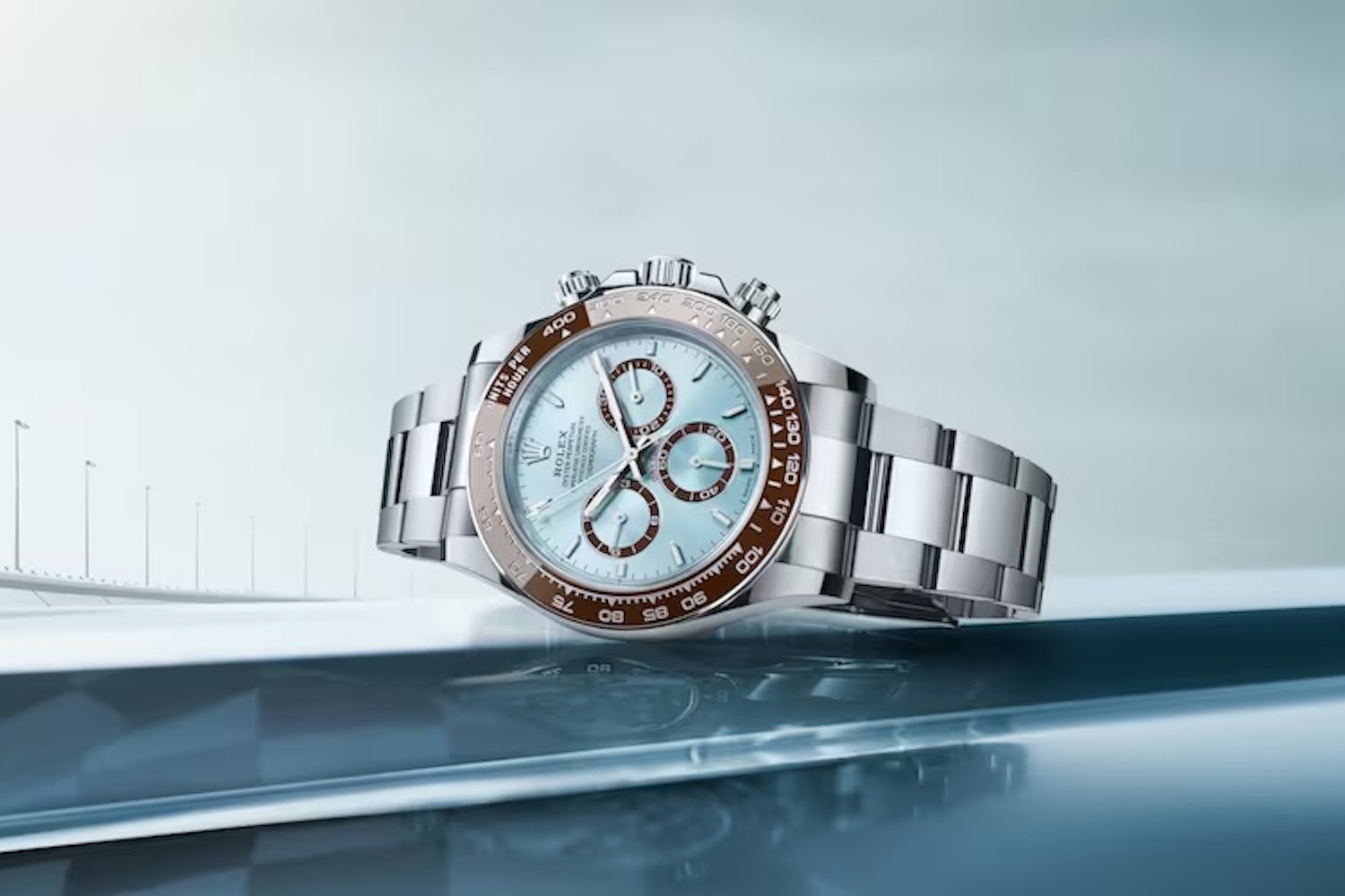 a blue-faced steel Rolex Daytona Watch 2023 on a blue background