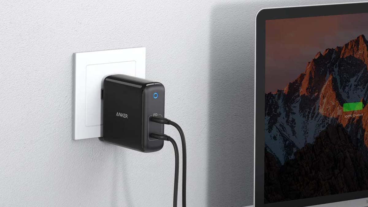 Anker's PowerPort Atom plugged into a wall and charging a laptop. Anker chargers are currently on sale at Amazon