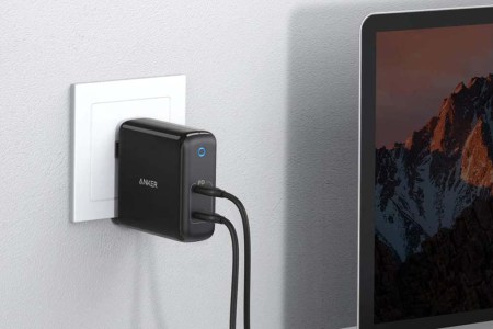 Anker's PowerPort Atom plugged into a wall and charging a laptop. Anker chargers are currently on sale at Amazon