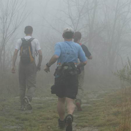 Three runners running into the fog at the Barkley Marathons.