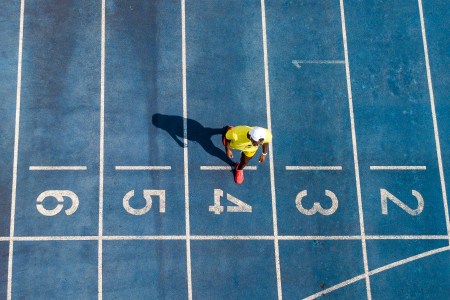 An athlete walking on a blue trrack.