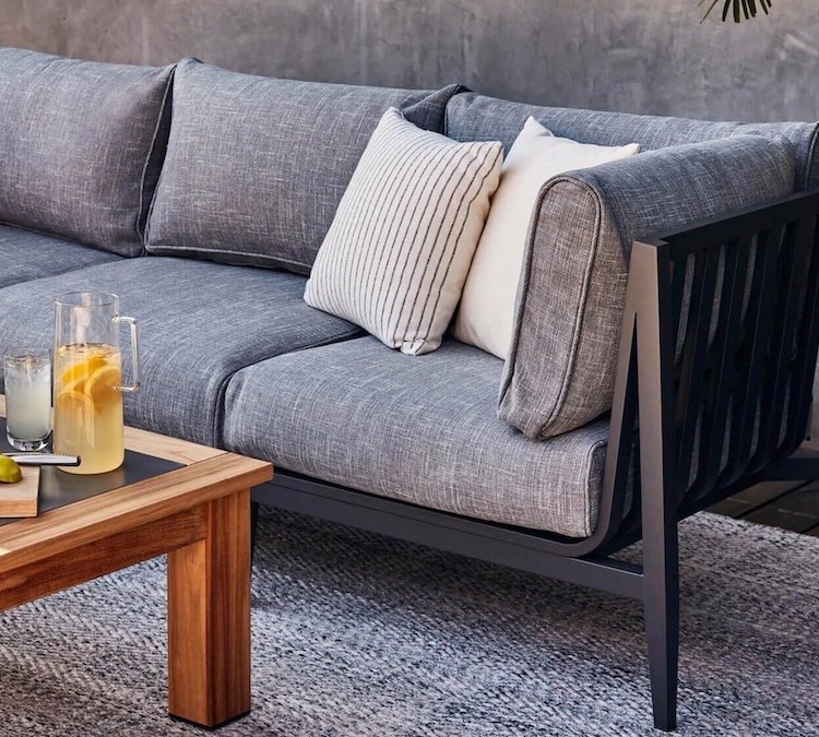 an grey Outer couch and wooden coffee table on a patio