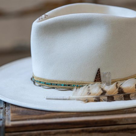 A white hat with a feather from Trovador Customs in Austin, Texas